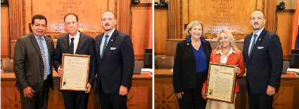 Legislators pose with honorees holding framed proclamations in the Board of Legislators chamber.