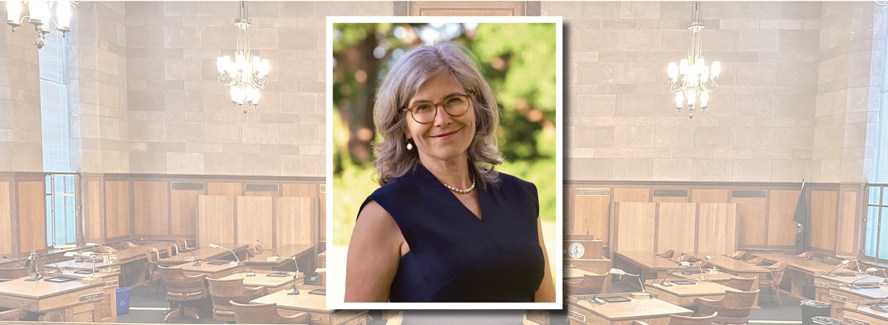 Legislator Erika Pierce headshot with Board Chamber in background.